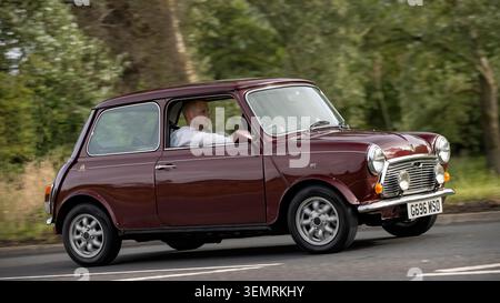 Stony Stratford, Bucks, Regno Unito - 7 giugno 2026: 1989 Austin Mini car rossa che guida su una strada britannica Foto Stock