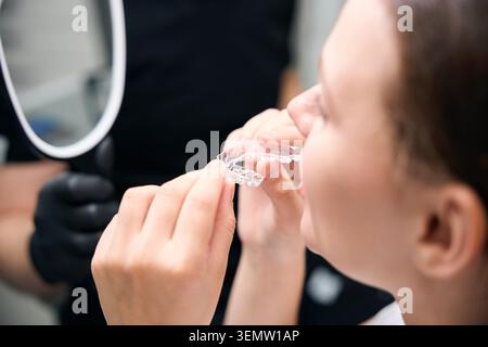 Donna che prepara allineatori dentali in studio medico Foto Stock