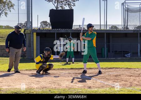 Video verticale: Avvicinamento del campo, batter in uniforme verde che oscilla sul piatto di casa per colpire la palla Foto Stock