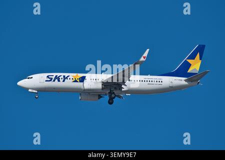Tokyo, Giappone - 18 dicembre 2022: Aereo passeggeri Skymark Airlines Boeing 737-800 (JA73NQ) in avvicinamento finale sotto il cielo azzurro Foto Stock