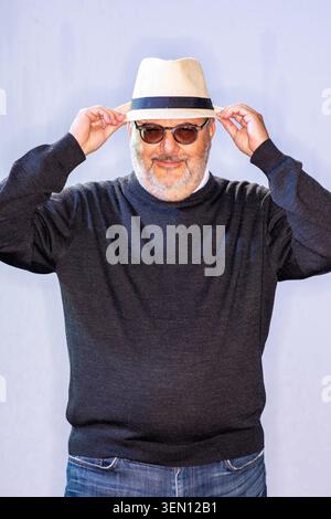 Branko Milanovic è in piedi con una postura rilassata, regolando il cappello e indossando gli occhiali da sole. È vestito con un maglione scuro e jeans. Lo sfondo è Foto Stock