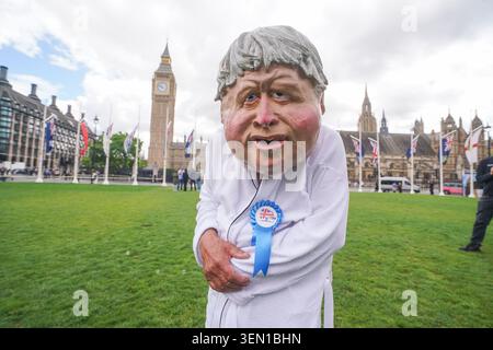 Sosia che indossa una maschera raffigurante l'ex primo ministro conservatore Boris Johnson che chiede di berare le donazioni politiche a Westminster Foto Stock