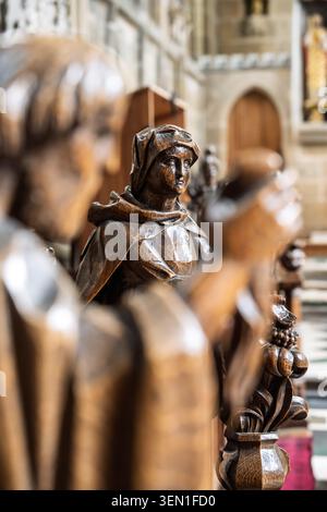 Composizione ravvicinata incentrata sul volto espressivo e sui dettagli di una storica statua in legno scolpita nelle bancarelle del coro della chiesa a Tideswell Foto Stock