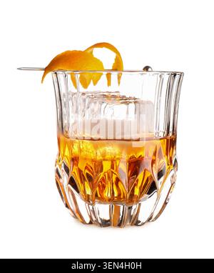 Classico cocktail vecchio stile con scorza d'arancia e grande cubetto di ghiaccio in un bicchiere di cristallo, la bevanda è guarnita con una scorza d'arancia ritorto su una Foto Stock