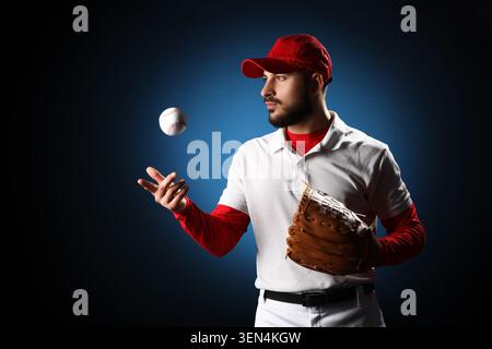 Giocatore di baseball con berretto rosso e uniforme bianca che cattura palla con guanto, allenamento sportivo e atletico Foto Stock