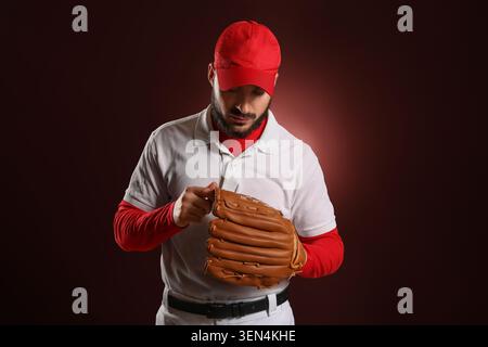 Giocatore di baseball con berretto rosso e uniforme bianca guanti in pelle marrone regolabile, allenamento sportivo e prestazioni atletiche, l'atleta dimostra il proprio rispetto Foto Stock