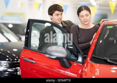 I giovani in una concessionaria di auto scelgono un'auto Foto Stock