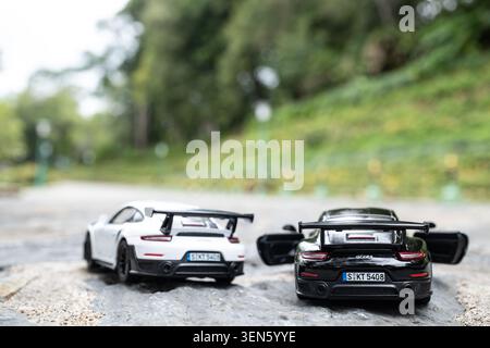 Chiang mai, Tailandia - 8 giugno 2026 : Porsche 911 GT2 RS 2018 in metallo pressofuso bianco e nero, vista posteriore accoppiata su pietra esterna Foto Stock