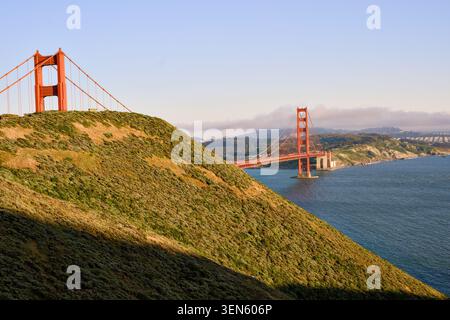 Marin Headlands, illuminati dal sole, incorniciano il Golden Gate Bridge sulla baia blu Foto Stock