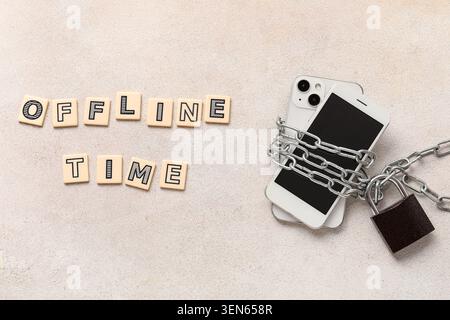 TEMPO offline con lo smartphone bloccato e incatenato, detox digitale e consapevolezza della dipendenza da Internet, lettere codificate indicano "TEMPO offline" Foto Stock