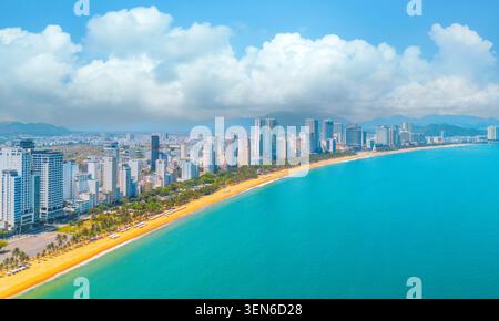 Spiaggia con vista aerea della città sulla principale costa dorata del sud-est asiatico nella calda giornata di sole di Nha Trang Foto Stock