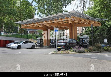 Stazione di ricarica per auto elettriche ESB Energy a Woolwich, a sud-est di Londra. Auto parcheggiate sotto una nuova struttura a baldacchino in legno laminato. Foto Stock