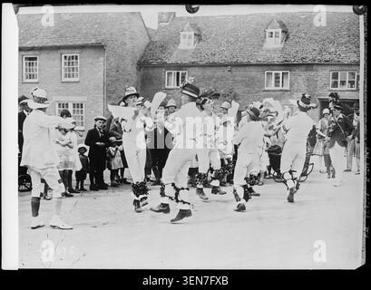 A Bampton, nell'Oxfordshire, un'usanza secolare continuò nel 1928 come un gruppo di Morris Dancers si esibì in varie parti della città, registrata in una fotografia di stampa riprodotta da un originale dell'agenzia Central News. Foto Stock