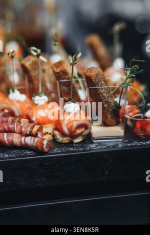 Gli antipasti delicati risplendono in una luce soffusa. Croccanti, freschi e invitanti, tentano i sensi. Serviti su vassoi scuri ed eleganti, promettono raffinatezza Foto Stock