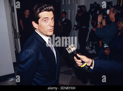 John Kennedy Jr, figlio dell'ex presidente Kennedy, si ferma a parlare con Entertainment Television durante gli arrivi degli ospiti per la cena di Stato in onore del primo ministro britannico Tony Blair, alla Casa Bianca il 5 febbraio 1998 a Washington, DC. Foto Stock