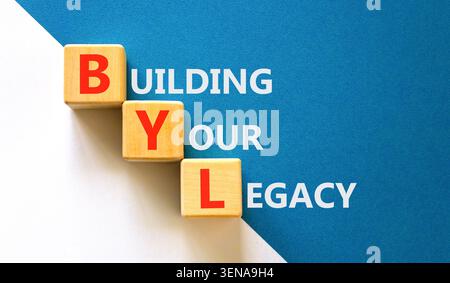 BYL sta costruendo il tuo simbolo legacy. Parole concettuali BYL costruisce la tua eredità su splendidi cubi di legno. Bellissimo sfondo bianco e blu. Business BYL Build Foto Stock