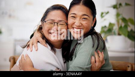 Felice, abbraccio e ritratto di donna con madre anziana in casa per legami, legami o famiglia. Sorriso, pensionamento e donna asiatica che abbraccia Foto Stock
