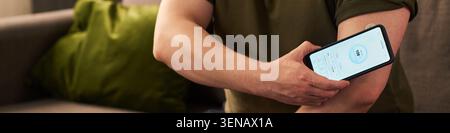 Uomo che monitora il diabete con smartphone Health Device a casa Foto Stock