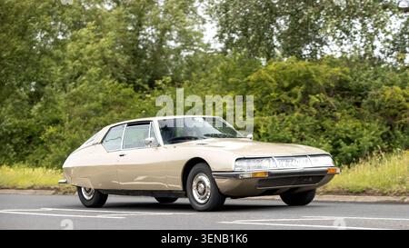 Stony Stratford, Bucks, Regno Unito - 7 giugno 2026: 1973 Citroen SM auto d'epoca che guida su una strada britannica Foto Stock