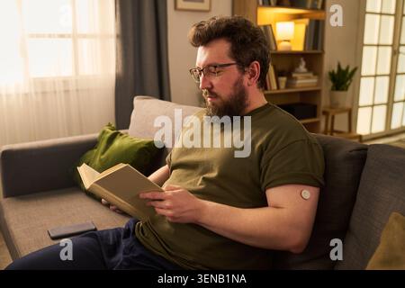 Uomo adulto con lettura del diabete a domicilio con sensore di glucosio Foto Stock