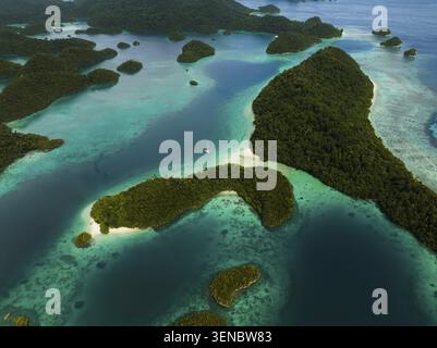 Vista aerea di molte piccole isole tropicali con acque turchesi e barriere coralline e catamarano a vela, Pulau Wayag, Raja Ampat, West Papua, Indo Foto Stock