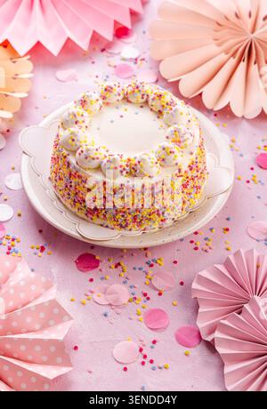 Deliziosa torta panna per la festa di compleanno con decorazioni in carta rosa Foto Stock