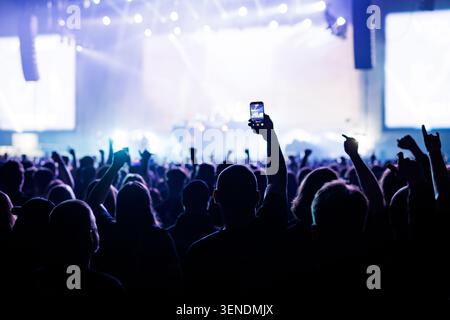 Silhouette sfocata di una folla che solleva le mani al Live Gig Foto Stock
