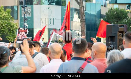 I manifestanti tengono bandiere albanesi, manifesti politici e telefoni cellulari durante una manifestazione pubblica. Foto Stock