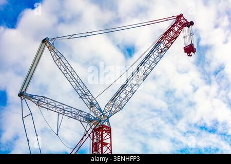 Fotografia della sezione superiore di una grande gru industriale contro un cielo nuvoloso blu vibrante in un cantiere nella Greater Western Sydney a New so Foto Stock