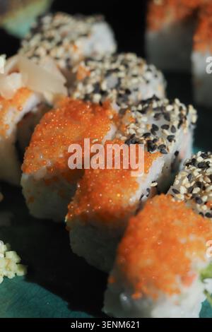 Panini di sushi posizionati su un piatto verde con condimenti Foto Stock