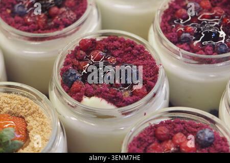 Dessert Magnolia con bacche miste e biscotti tritati in vasetti di vetro. budino turco Foto Stock