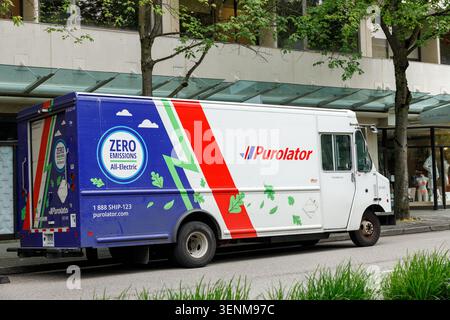 Vancouver, Canada - 8 giugno 2026: Un furgone Purolator interamente elettrico a emissioni zero avvolto in una grafica blu verde e rossa è parcheggiato lungo un sottotetto Foto Stock