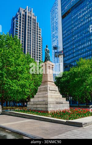 Montreal, Quebec, Canada - 21 maggio 2026: Statua della Regina Vittoria Memorial con tulipani in Victoria Square. Foto Stock