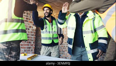 Ingegnere, team e cinque in cantiere con progetto, celebrazione e discussione per la progettazione di edifici. Architetto, uomini e planimetria con Foto Stock