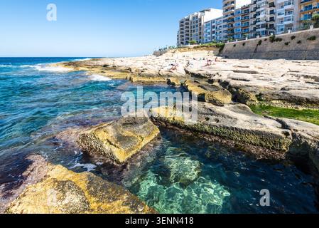 Sliema, Malta - 16 maggio 2025: Vista delle famose terme romane di Sliema, piscine in pietra naturale lungo la costa mediterranea, rinomate per la ba Foto Stock