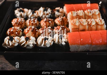 sushi preparato con panini, nigiri e condimenti perfettamente allineati, sushi selezionato con riso e salsa al salmone, vivace composizione di piatti a base di pesce, primo piano Foto Stock