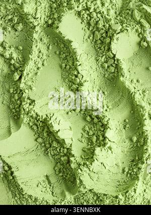 Primo piano full-frame di una vivace consistenza verde di tè matcha in polvere. La polvere organica liscia e finemente macinata crea un solido sfondo astratto con Foto Stock