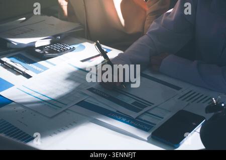 Tabella riportata sopra con documenti finanziari, grafici e big data durante la riunione di lavoro di squadra con il team di contabilità o marketing che discute di budget, strategia o crescita d Foto Stock