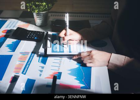 Tabella riportata sopra con documenti finanziari, grafici e big data durante la riunione di lavoro di squadra con il team di contabilità o marketing che discute di budget, strategia o crescita d Foto Stock