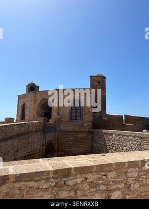Storica fortezza in pietra e mura difensive a Essaouira, Marocco, sotto un cielo azzurro. Foto Stock