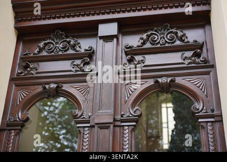 Vista dettagliata della porta d'ingresso storica in legno decorata con intagli e pannelli di vetro al Planufer di Kreuzberg, Berlino, Germania. Foto Stock