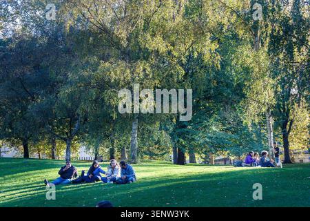 Persone sedute a St James's Park, Londra, Inghilterra, Regno Unito Foto Stock