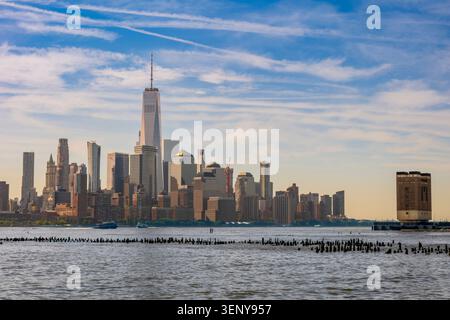 New York, New York - Stati Uniti - 5 giugno 2026 Una splendida vista dell'iconico skyline di Lower Manhattan sotto un cielo blu luminoso, con l'imponente One World Trade CE Foto Stock