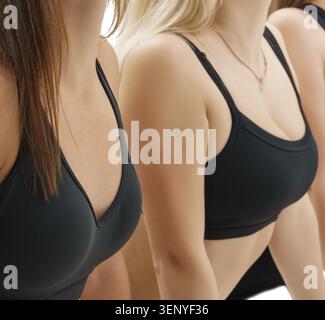 Ragazze sottili e sportive con top e leggings neri che si allenano in uno studio di registrazione ravvicinata Foto Stock
