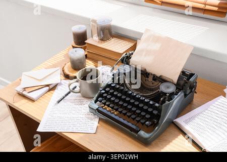 Macchina da scrivere vintage con carta bianca, caffè e libri su una scrivania di legno, scrittura creativa e narrazione Foto Stock