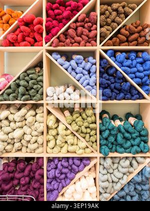 Ripiani pieni di colorate schegge di filati e lana in un negozio di artigianato Foto Stock