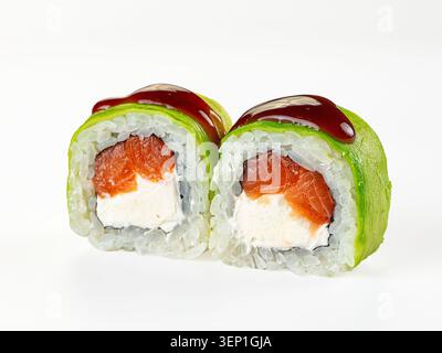 Due sushi roll con salmone fresco, formaggio spalmabile e avocado avvolti in riso, conditi con salsa lucida, isolati su sfondo bianco Foto Stock