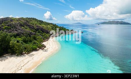 Spiaggia tropicale con sabbia dorata e mare blu con onde. Curieuse, Seychelles. Foto Stock