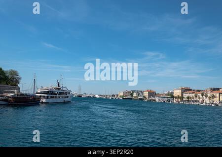 Un pomeriggio di sole sul tranquillo canale del Mar Adriatico a Zara, caratterizzato da architettura storica, edifici moderni e molte barche ormeggiate. Foto Stock
