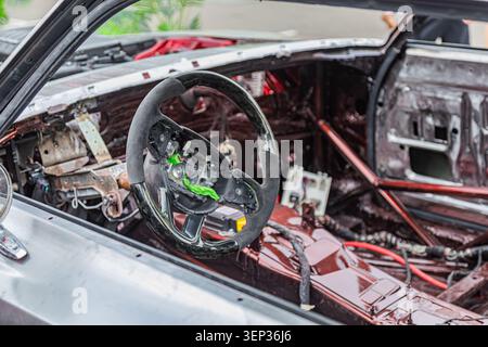 Gli interni della vettura sono in fase di restauro e presentano componenti esposti del cruscotto e cablaggi, con volante parzialmente smontato con Foto Stock